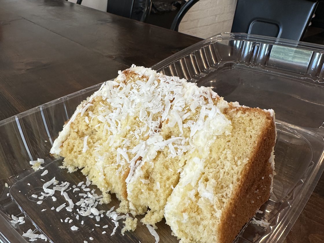 A slice of coconut cake, boxed and ready to go at Twisted Whisk
